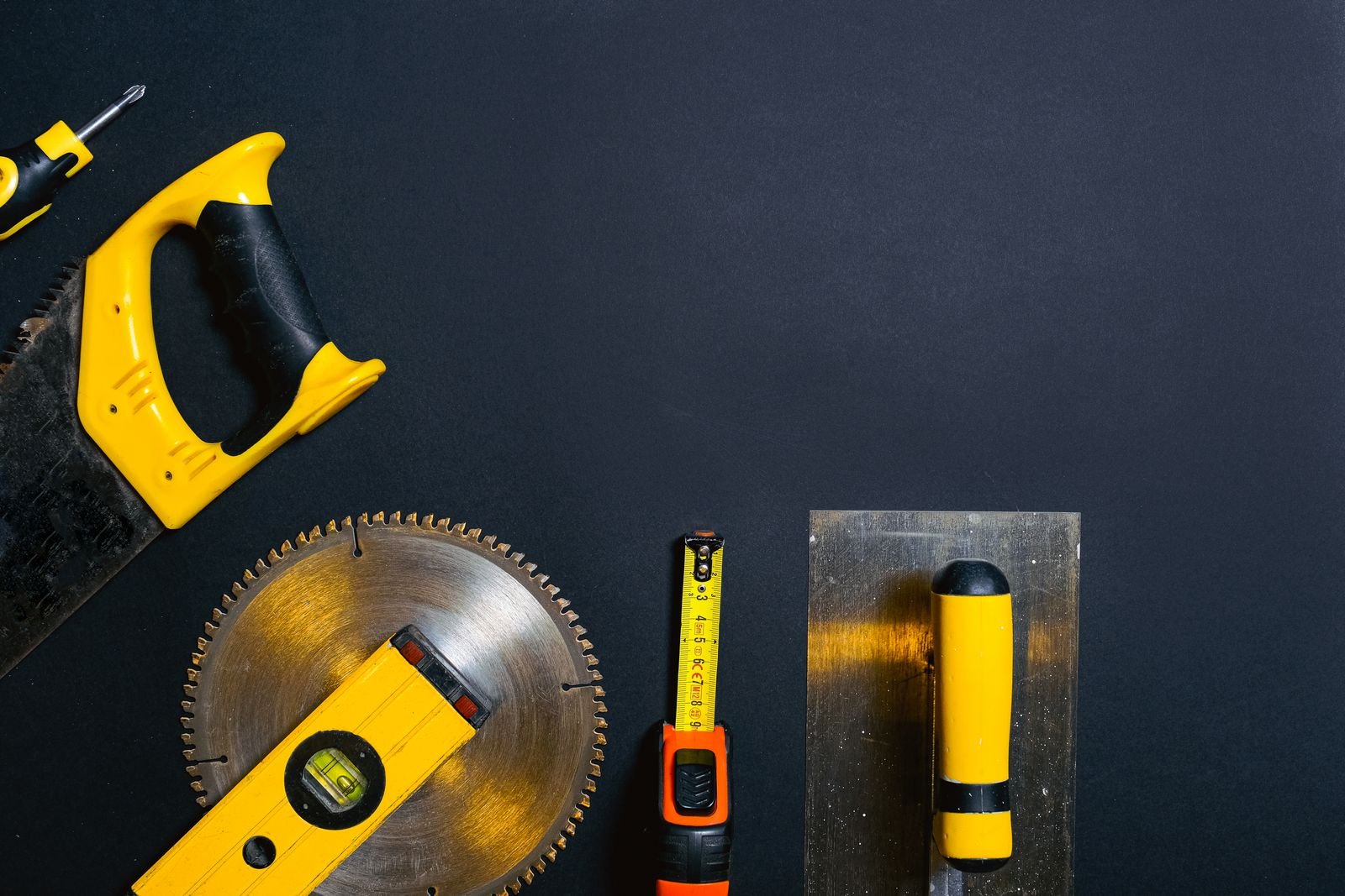 Hardware and construction tools — saw, tape measure, level, and trowel
